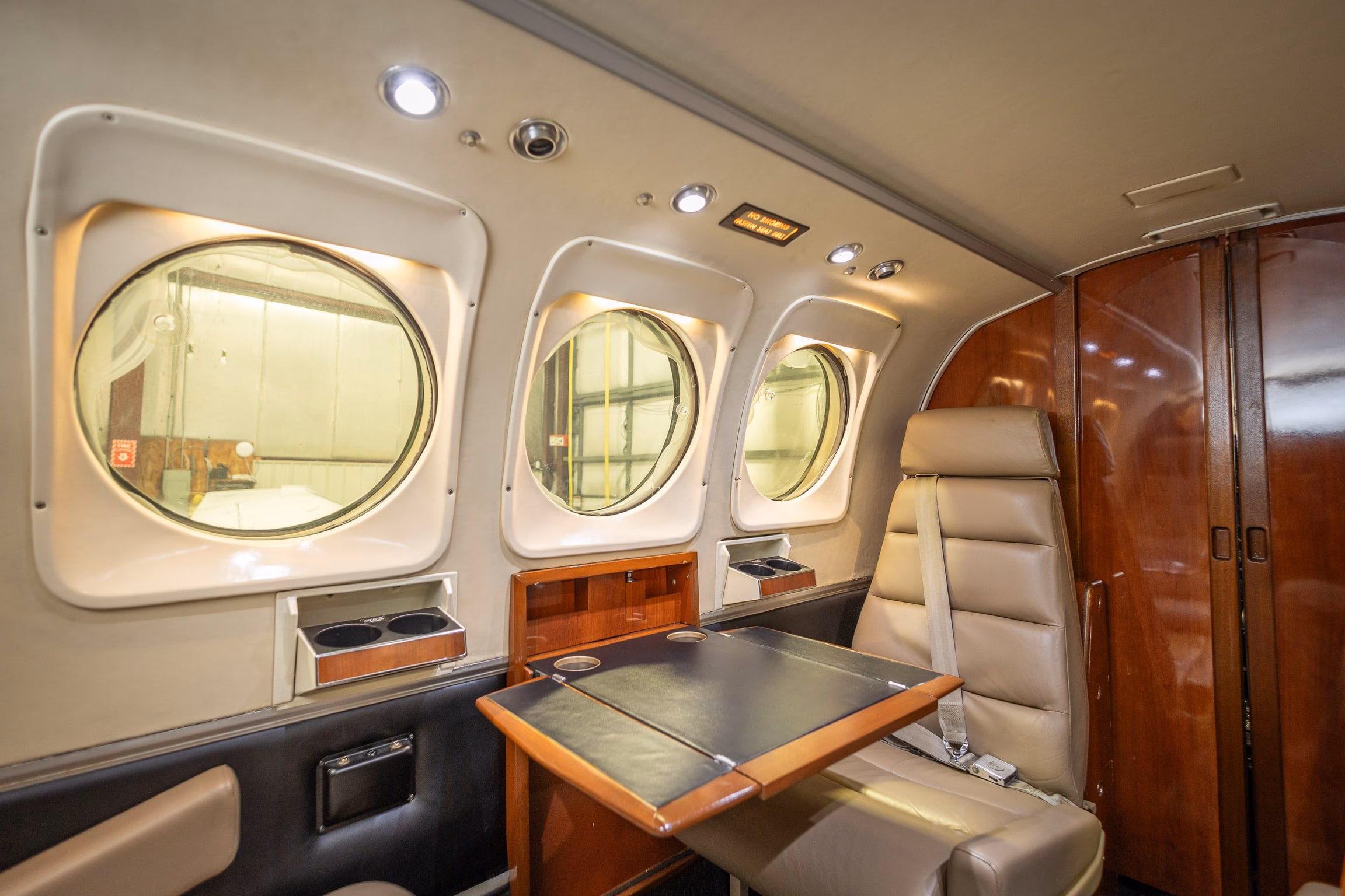 1982 Beechcraft King Air C90 cabin side detail with table, seating, and storage cabinet
