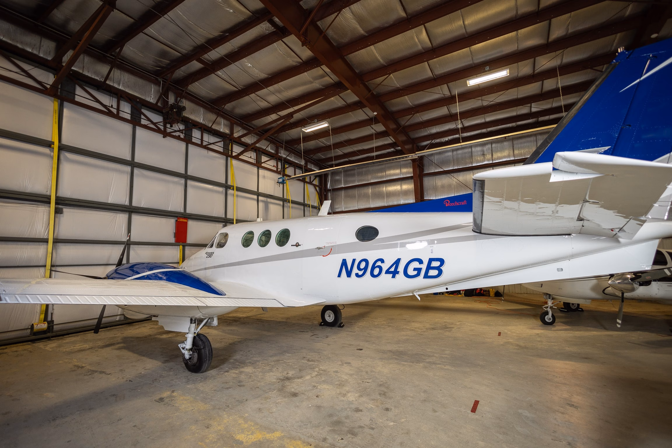 1982 Beechcraft King Air C90 N964GB rear left fuselage and tail view in hangar