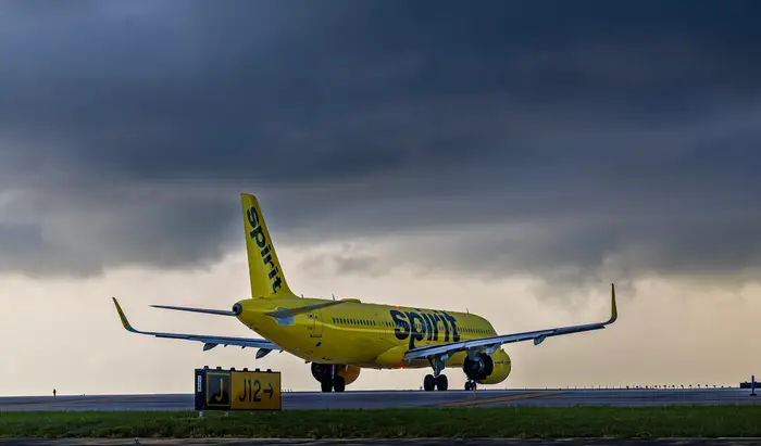 Spirit Airlines shutdown with yellow Airbus aircraft on a stormy runway, reflecting the end of the carrier’s bare-fare airline model.